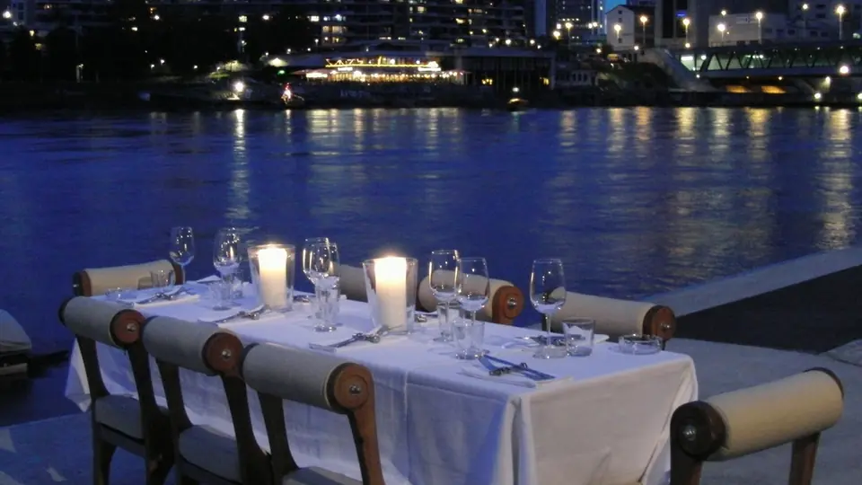 Sicheres Sexdate: ein gedeckter Tisch mit Kerzen am Wasser bei Nacht