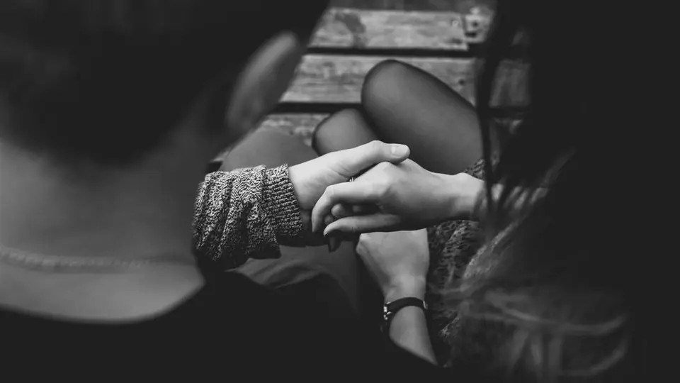 Sexdate per App: zwei Hände halten sich im Halbdunkel