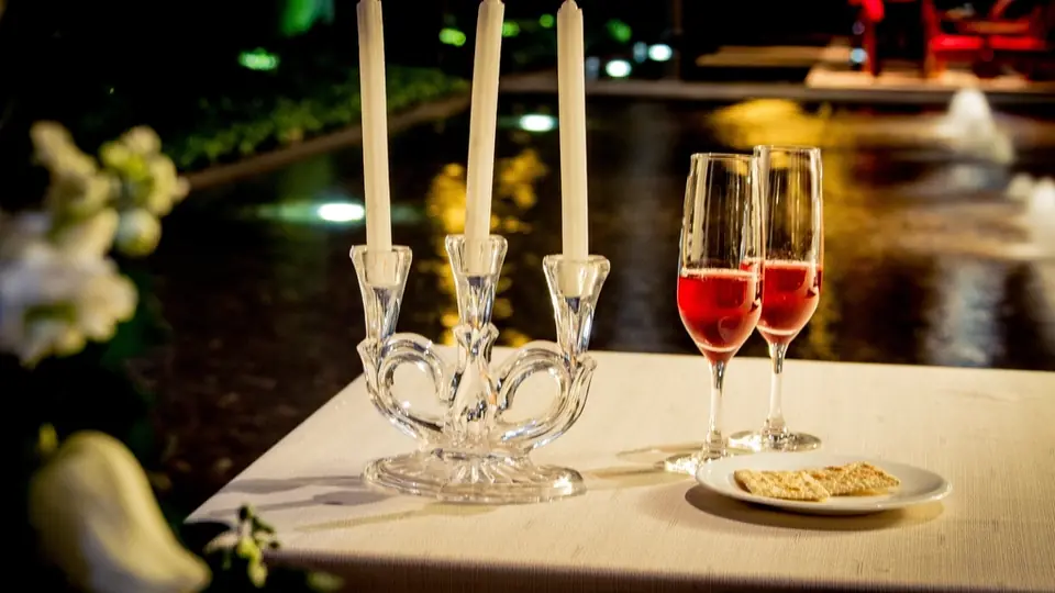 Ein Sexdate mit Stil: Kerzen und zwei Gläser Rotwein auf einem Tisch